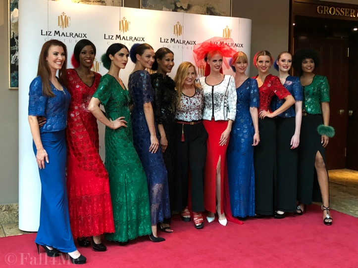 The designer in the center of her models and the host